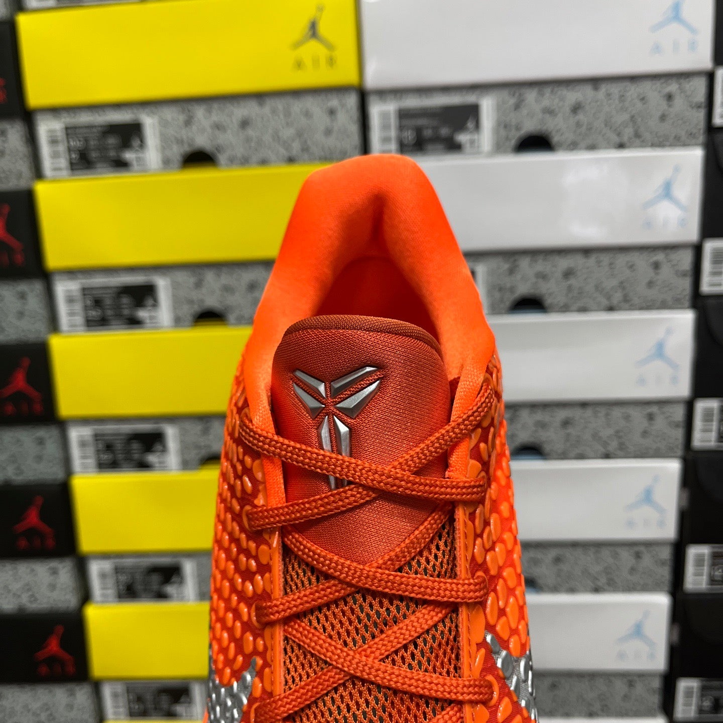 Orange sneaker heel with lace-up top and embroidered logo on back tab