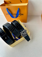 Dark navy croc belt with interlaced metal buckle, shown laid in box