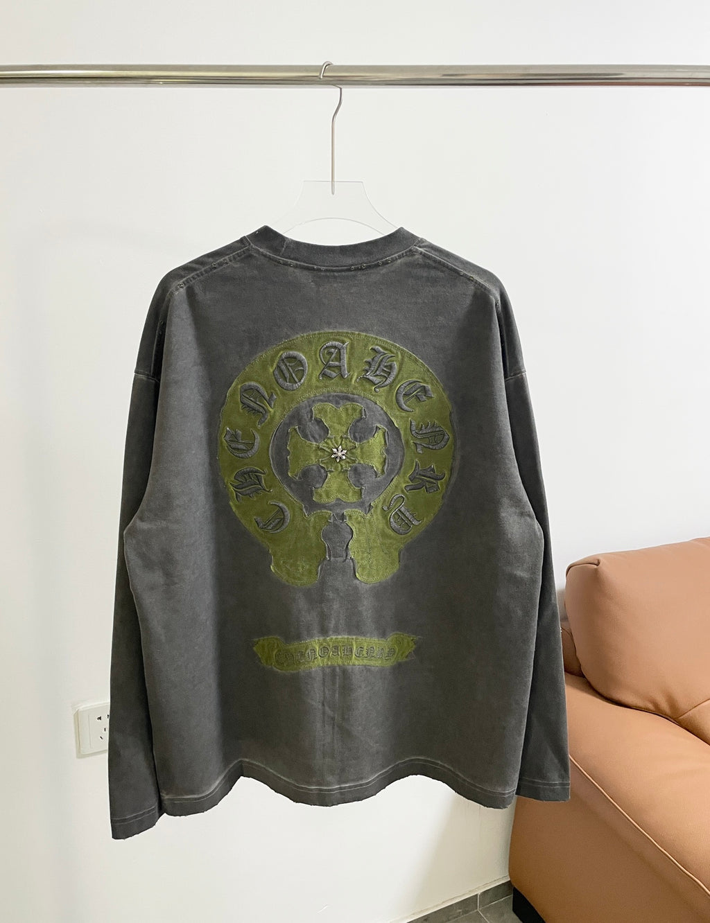 Dark gray long-sleeve T-shirt back with large green circular graphic and text.