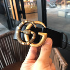 Black leather belt showing gold-tone buckle and clasp at front