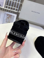 Balenciaga black suede slip-on sandal close-up with black strap logo patch