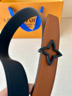 Tan leather belt with dark navy edging and large star-shaped buckle, close-up