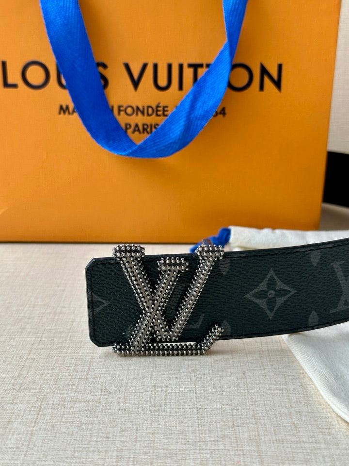 Louis Vuitton belt close-up with dark blue monogram strap and LV rhinestone buckle