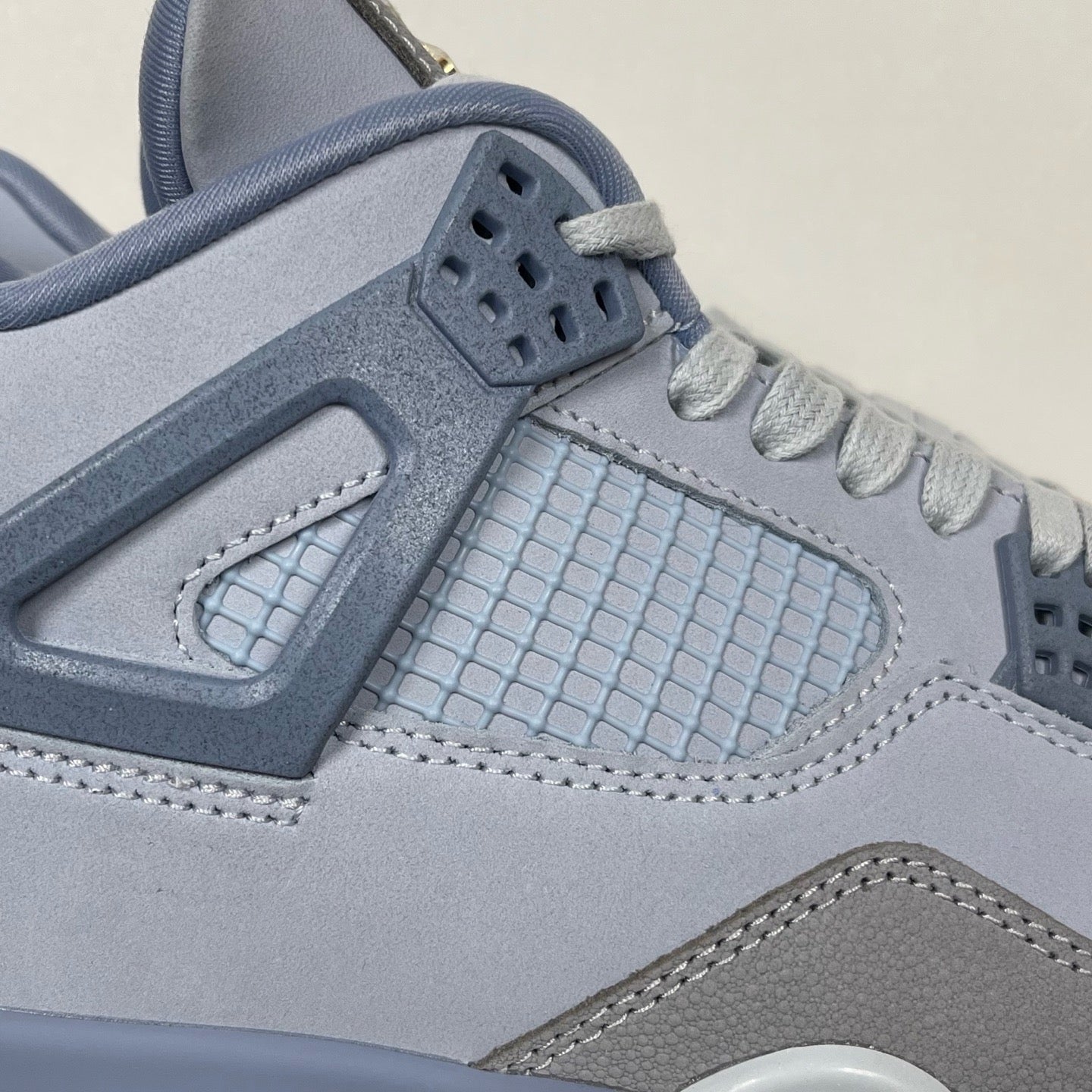 Close-up of light blue Air Jordan 4 tongue area, grid-texture panel, and heel tag