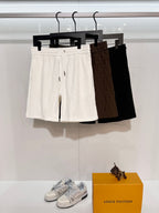 Dior drawstring shorts set, white, brown, and black on hangers