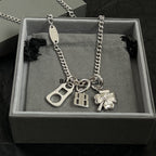 Balenciaga silver pendant necklace in box with clover, BB, and keyhole charms