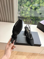 Black Chanel slingback shoes with pointed toe and textured upper, shown from side