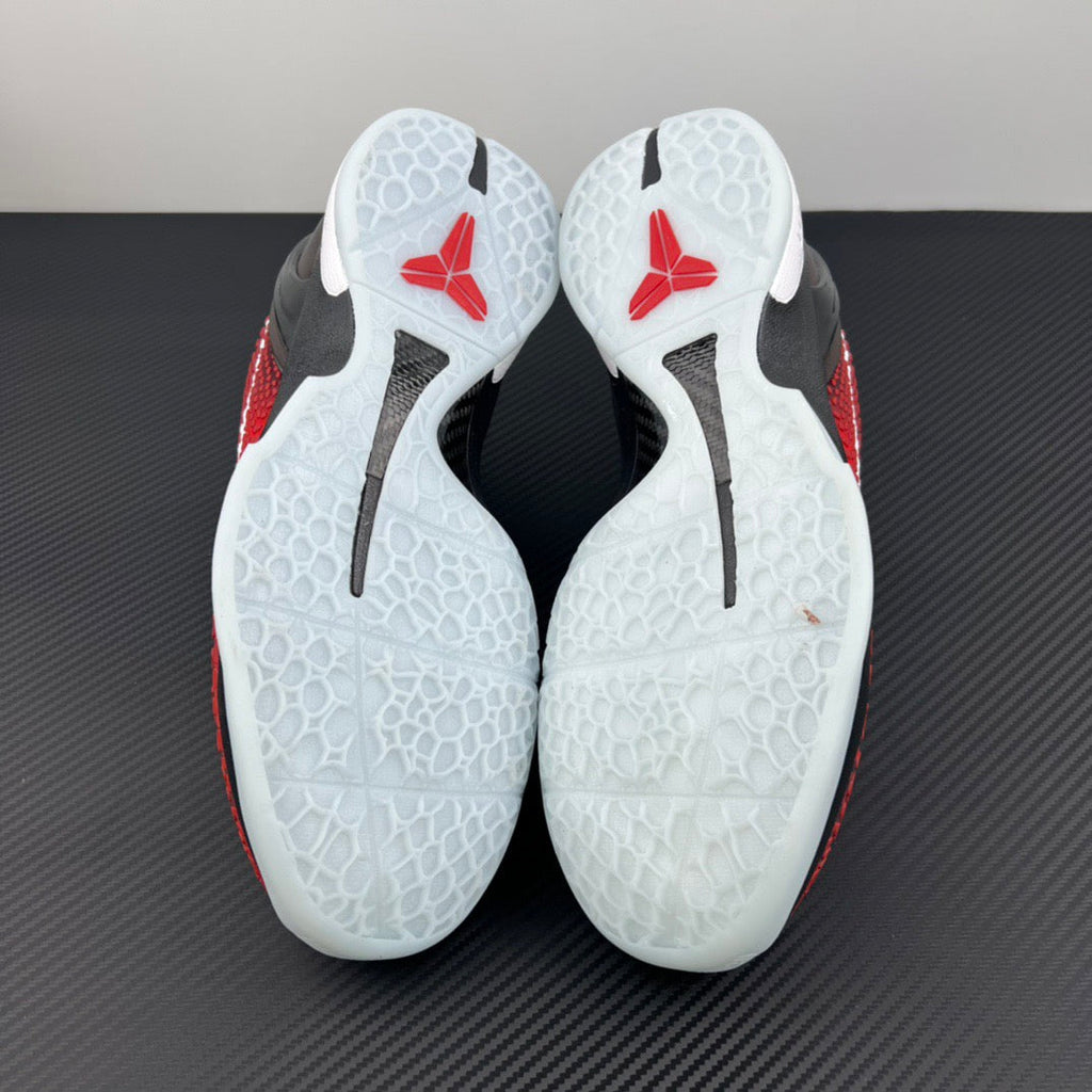 Shoe soles with white traction pattern and red heel sections with black markings.