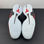 Shoe soles with white traction pattern and red heel sections with black markings.