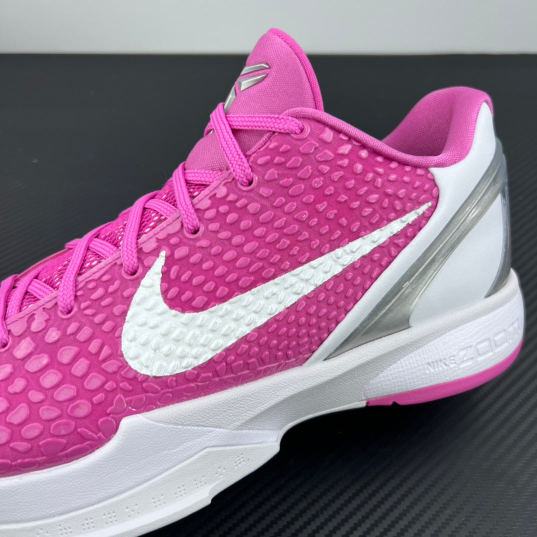 Side view of pink low-top sneaker with white swoosh and silver-toned heel panel