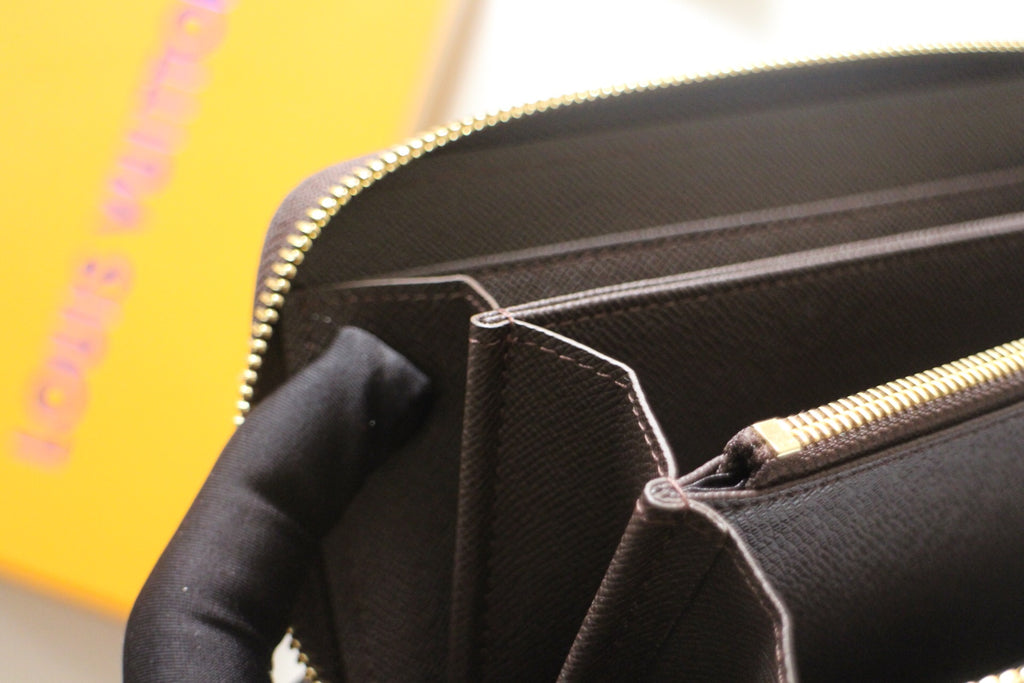 Louis Vuitton small bag interior view with zipper edge and slip pockets.