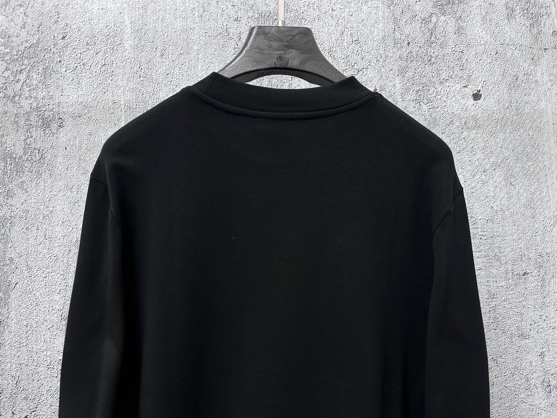 Black long-sleeve sweatshirt back view, plain design