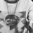 Chrome accessories necklace with silver chain and dagger pendant, worn on graphic shirt