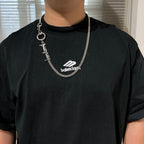 Balenciaga chain necklace with round clasp and logo charm on black shirt