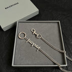 Silver-tone keychain with ring and logo tag on tray