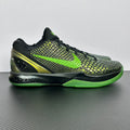 Black and green basketball shoes with neon laces, textured upper, lime outsole edge.