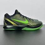 Black and green basketball shoes with neon laces, textured upper, lime outsole edge.