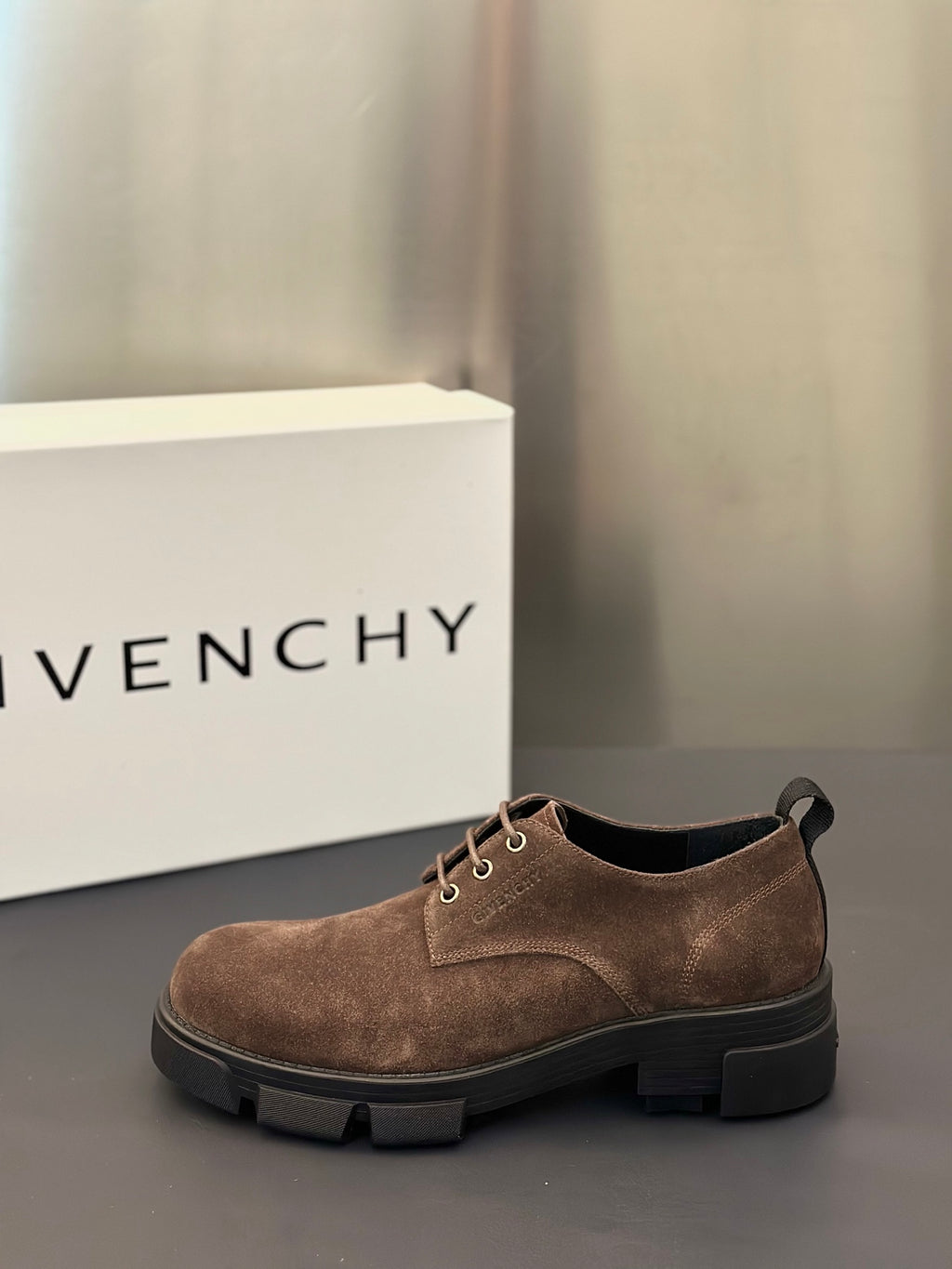 Brown suede lace-up shoe with round toe, metal eyelets, and chunky dark sole