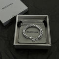 Silver chain bracelet in gift box with BALENCIAGA logo engraving and black tassel accents