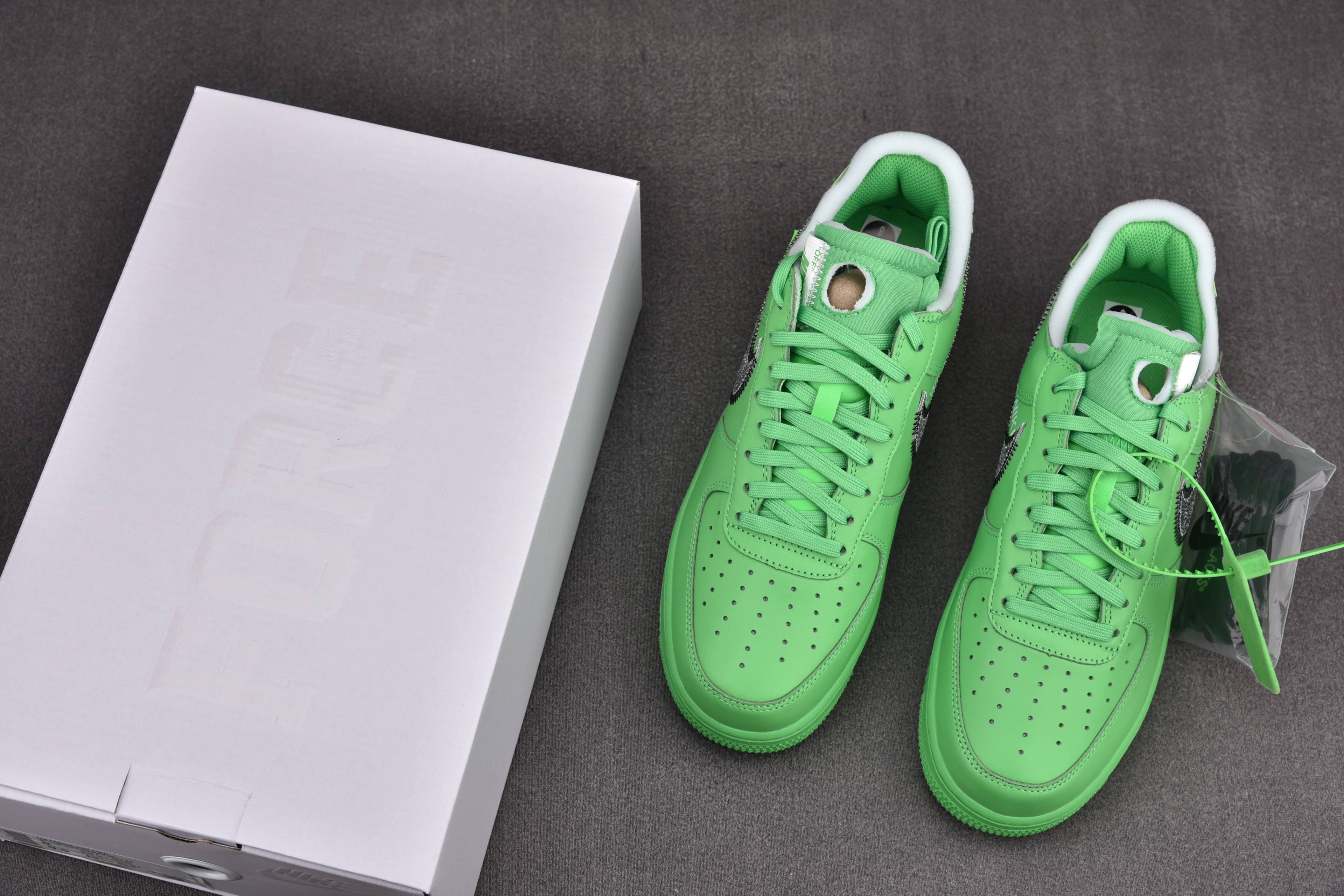 Pair of green low-top sneakers with white soles, displayed with a white shoebox