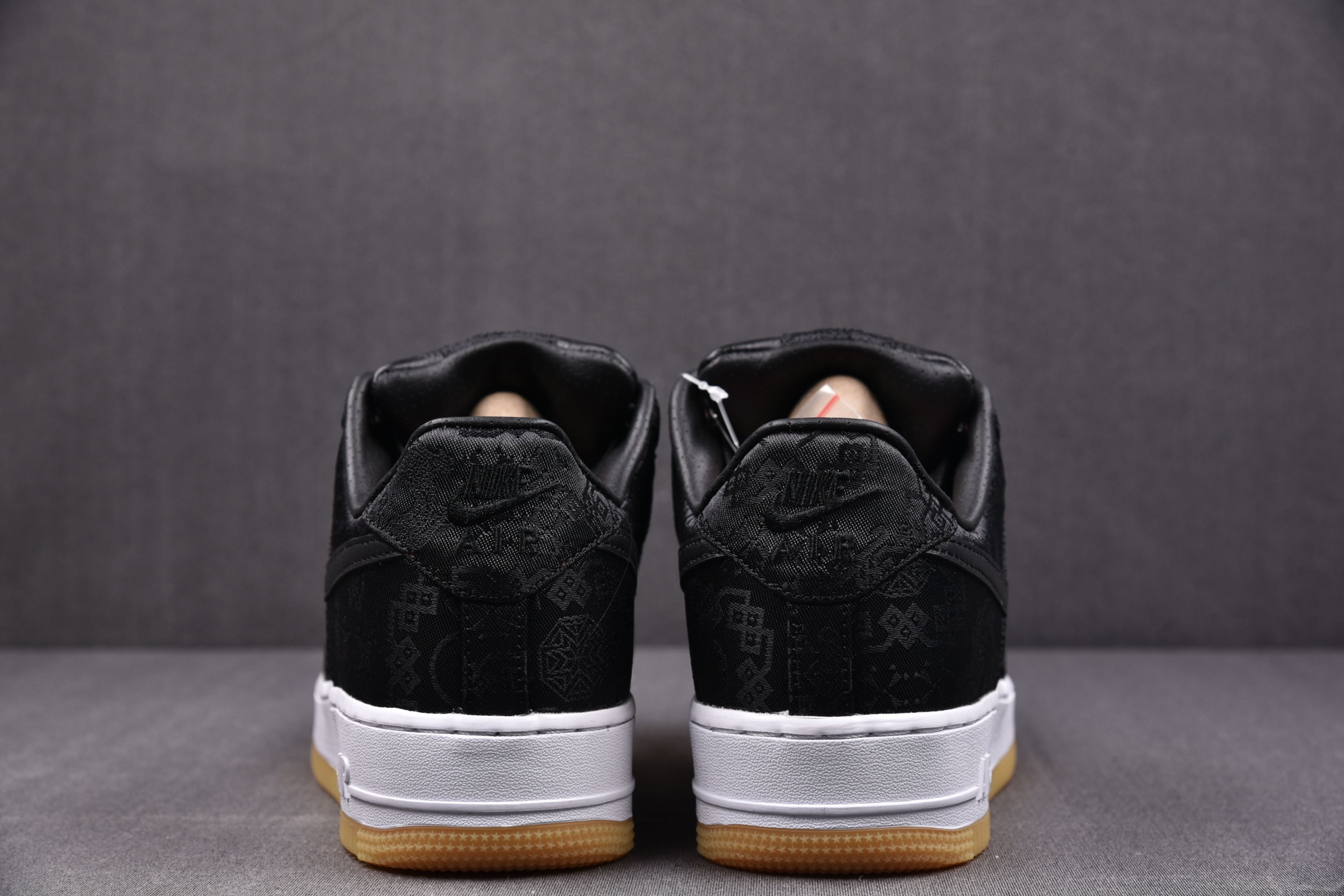 Black low-top sneakers with white midsoles and gum soles