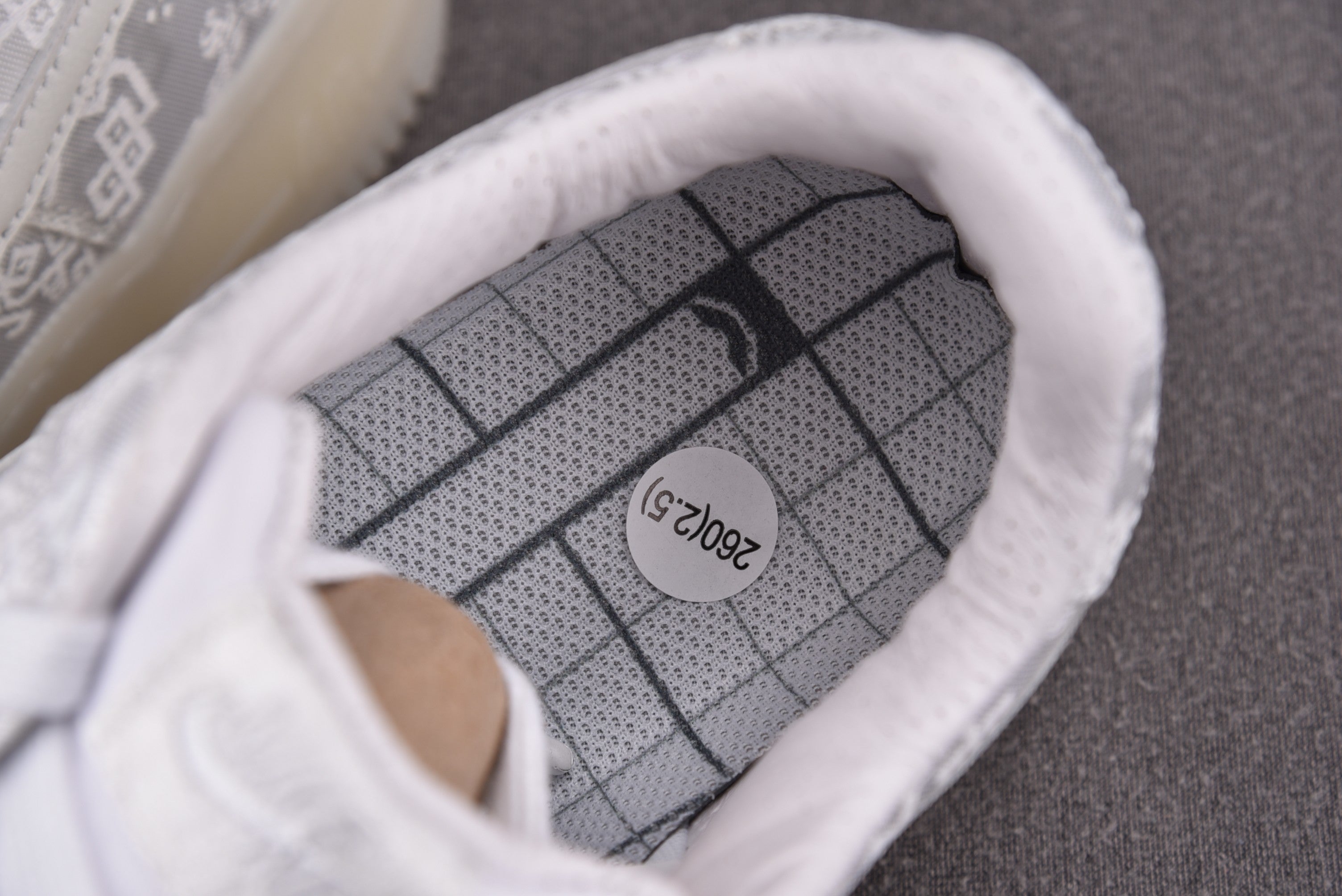 Close-up of white low-top sneakers inner sole with grid pattern branding
