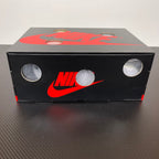 Shoe box with Nike logo in red on dark cover