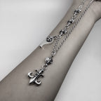 Silver chain necklace with fleur-de-lis and lock charms, worn on wrist
