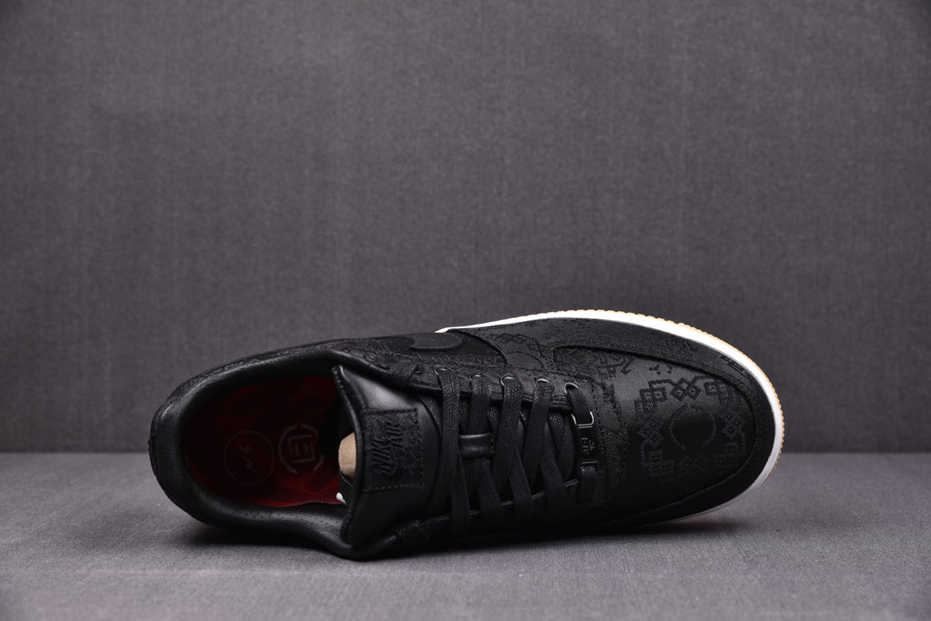 Black low-top sneaker with black laces, embossed upper pattern, white midsole