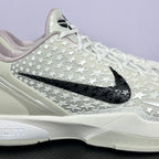 Low-top basketball sneaker close side, white star-pattern upper, black swoosh, white sole