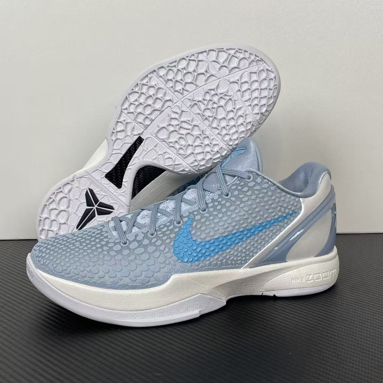 Light blue and gray basketball shoes with black traction star on white outsole, lace-up.
