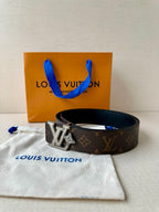 Louis Vuitton monogram belt laid out, dark leather strap with gold logo buckle