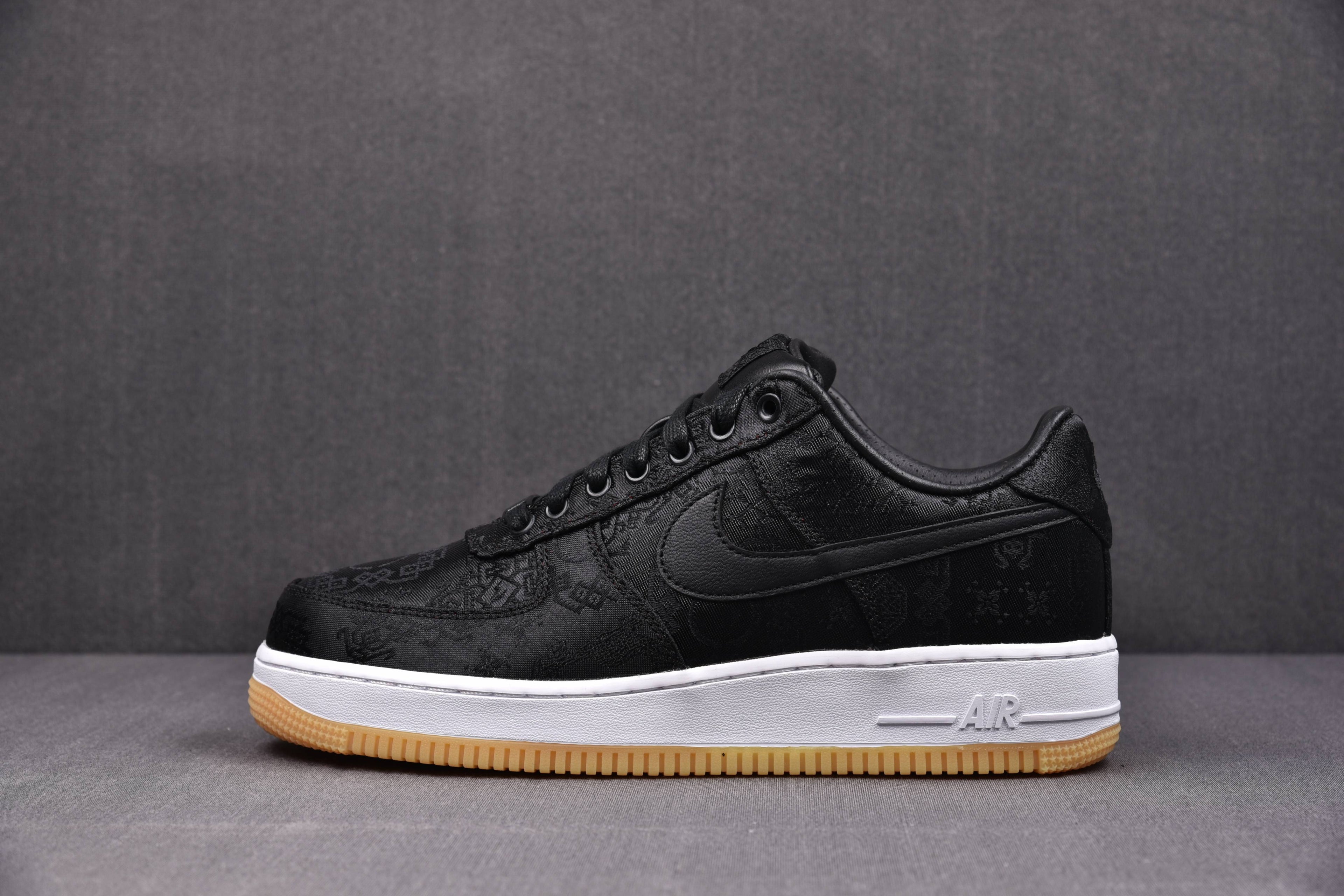 Black low-top sneaker with Swoosh, Air detail on midsole, white midsole, gum outsole