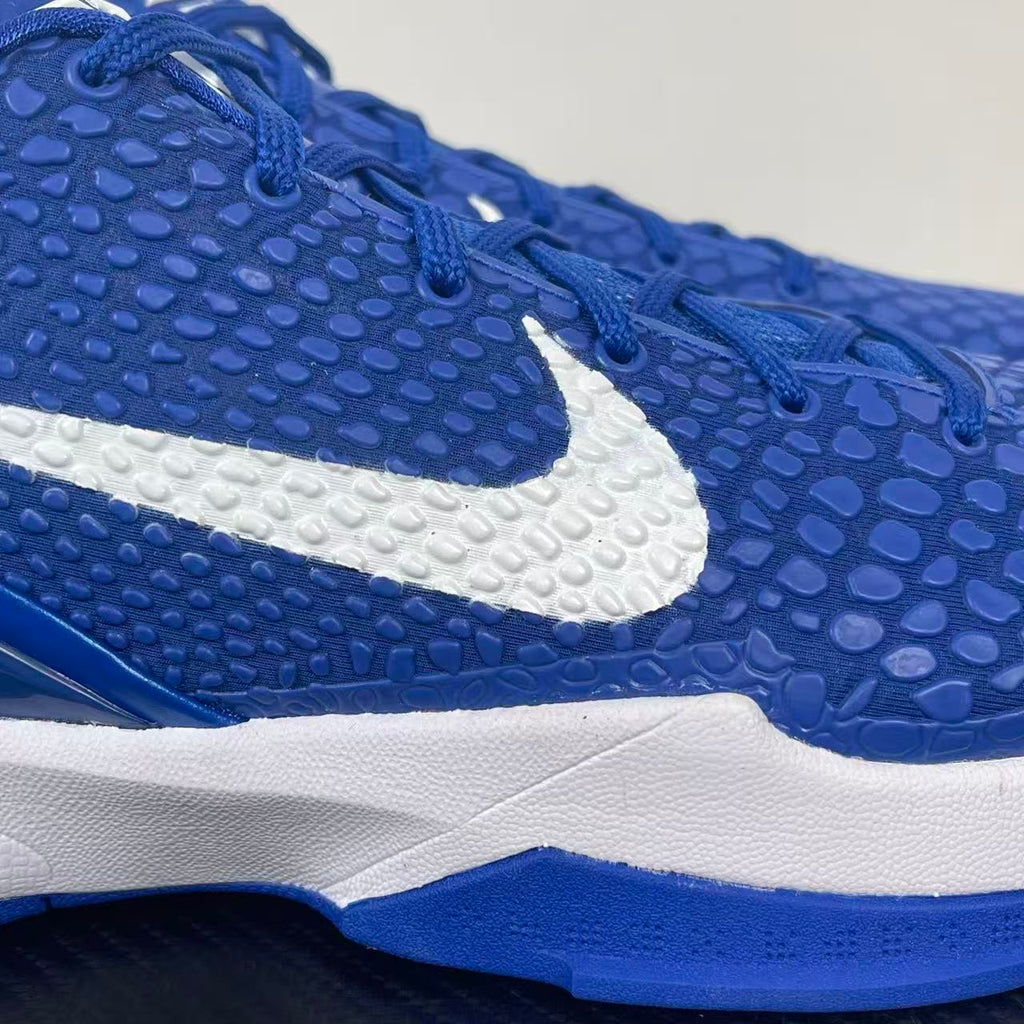 Blue Nike sneaker upper close-up with textured pattern and white swoosh stripe