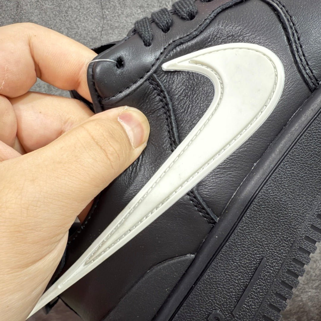 Black sneaker side view with white Nike Swoosh and textured midsole