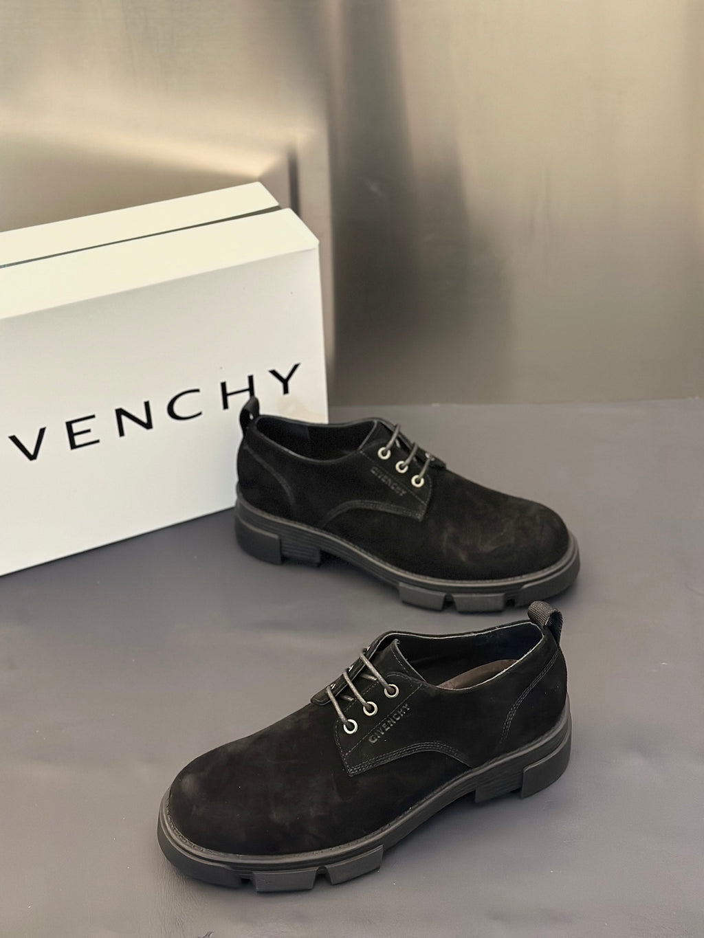Black lace-up shoes with metal eyelets and low stacked rubber heel.