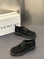 Black lace-up shoes with metal eyelets and low stacked rubber heel.
