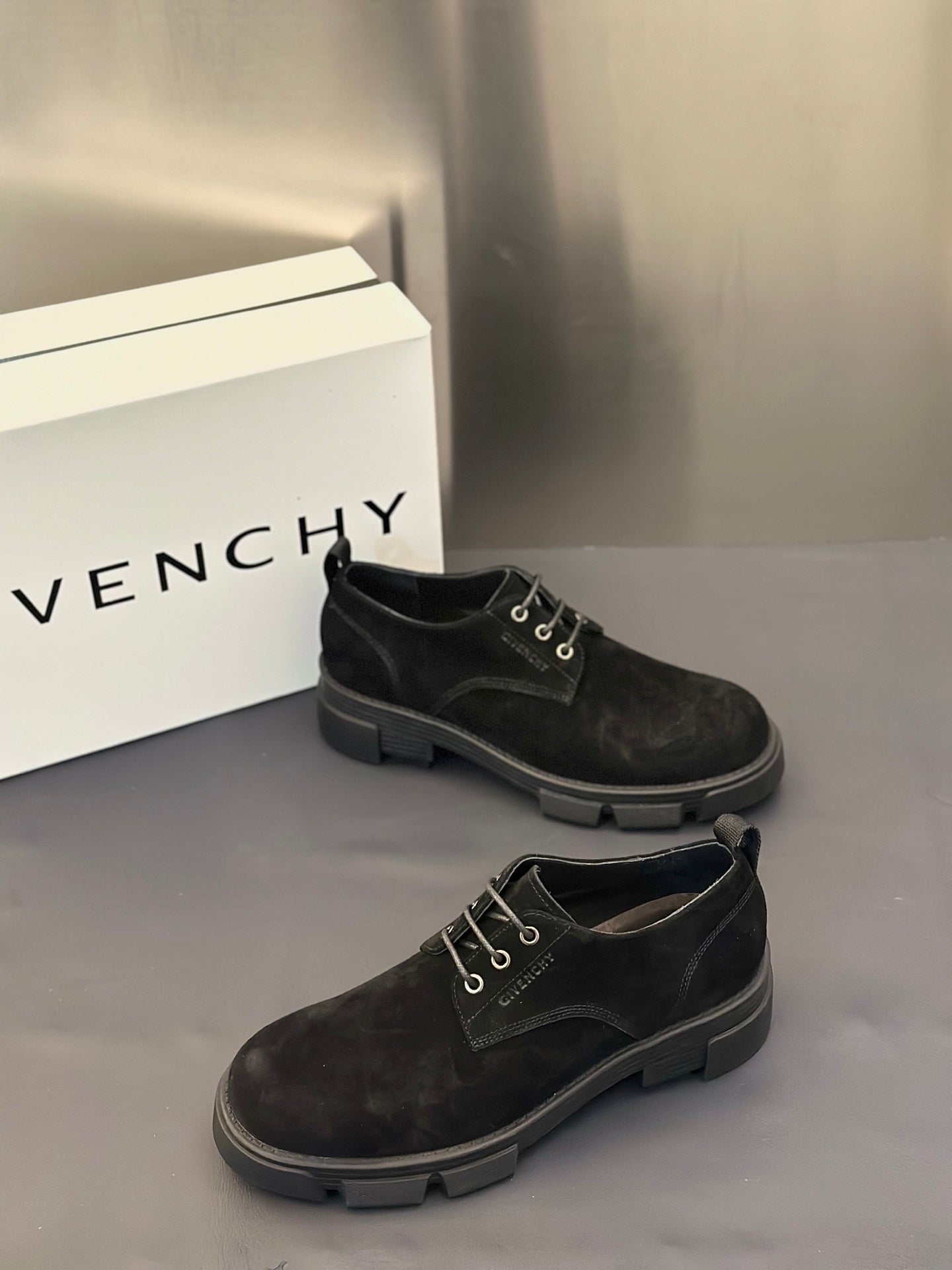 Black lace-up shoes with metal eyelets and low stacked rubber heel.