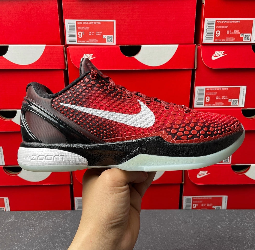 Red athletic shoe with textured upper, white swoosh, black sole, and black laces
