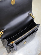 Black leather wallet bag open view with gold-tone zip, button, and chain strap.