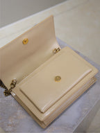 YSL cream flap bag with gold-tone clasp and back strap loop detail