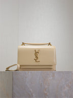 YSL small flap bag in cream with gold-tone chain strap and YSL logo front