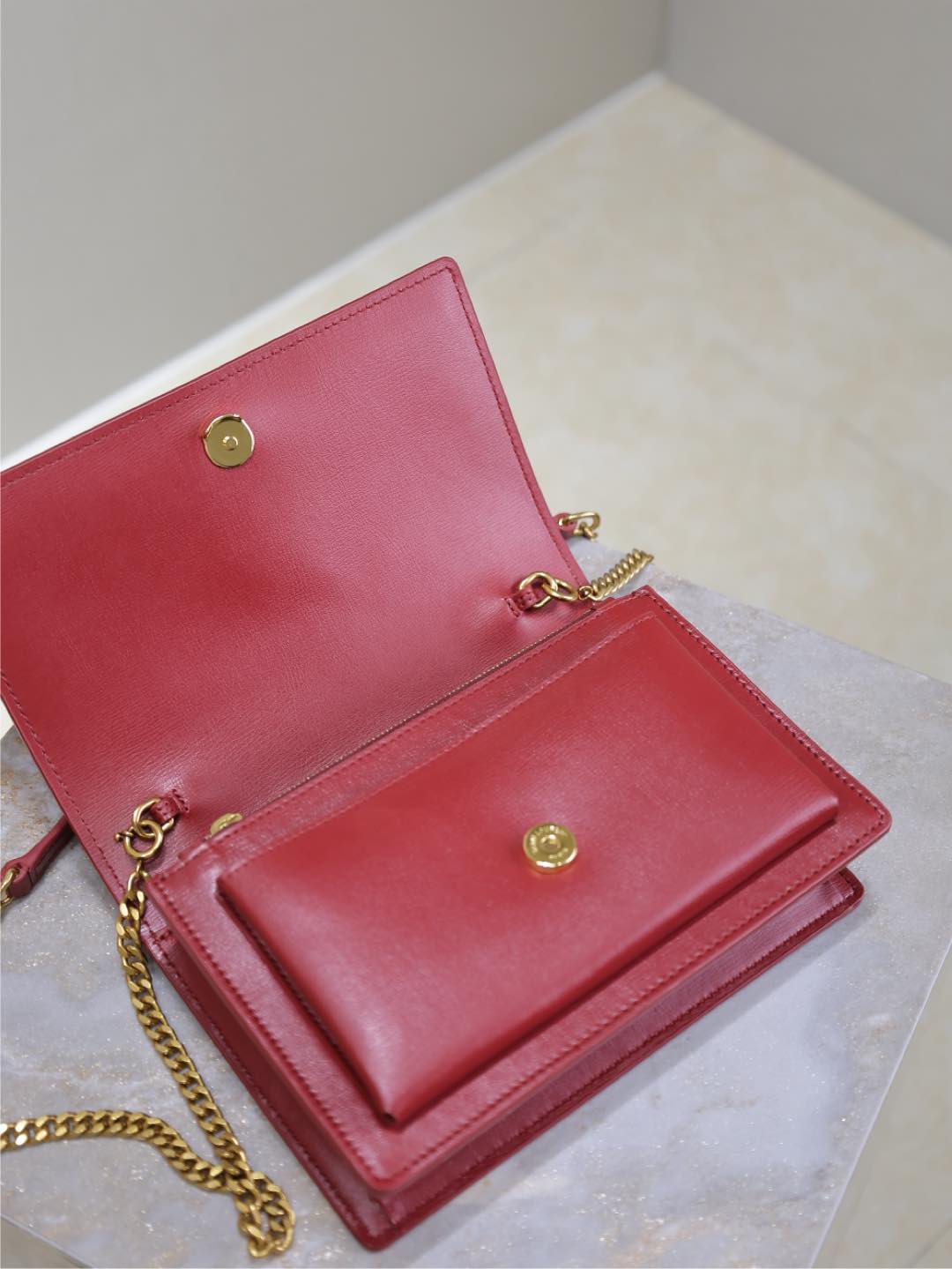 YSL red leather flap bag with open interior, gold snap buttons
