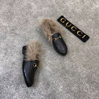 Gucci black loafer with faux fur trim and gold bit hardware, side view
