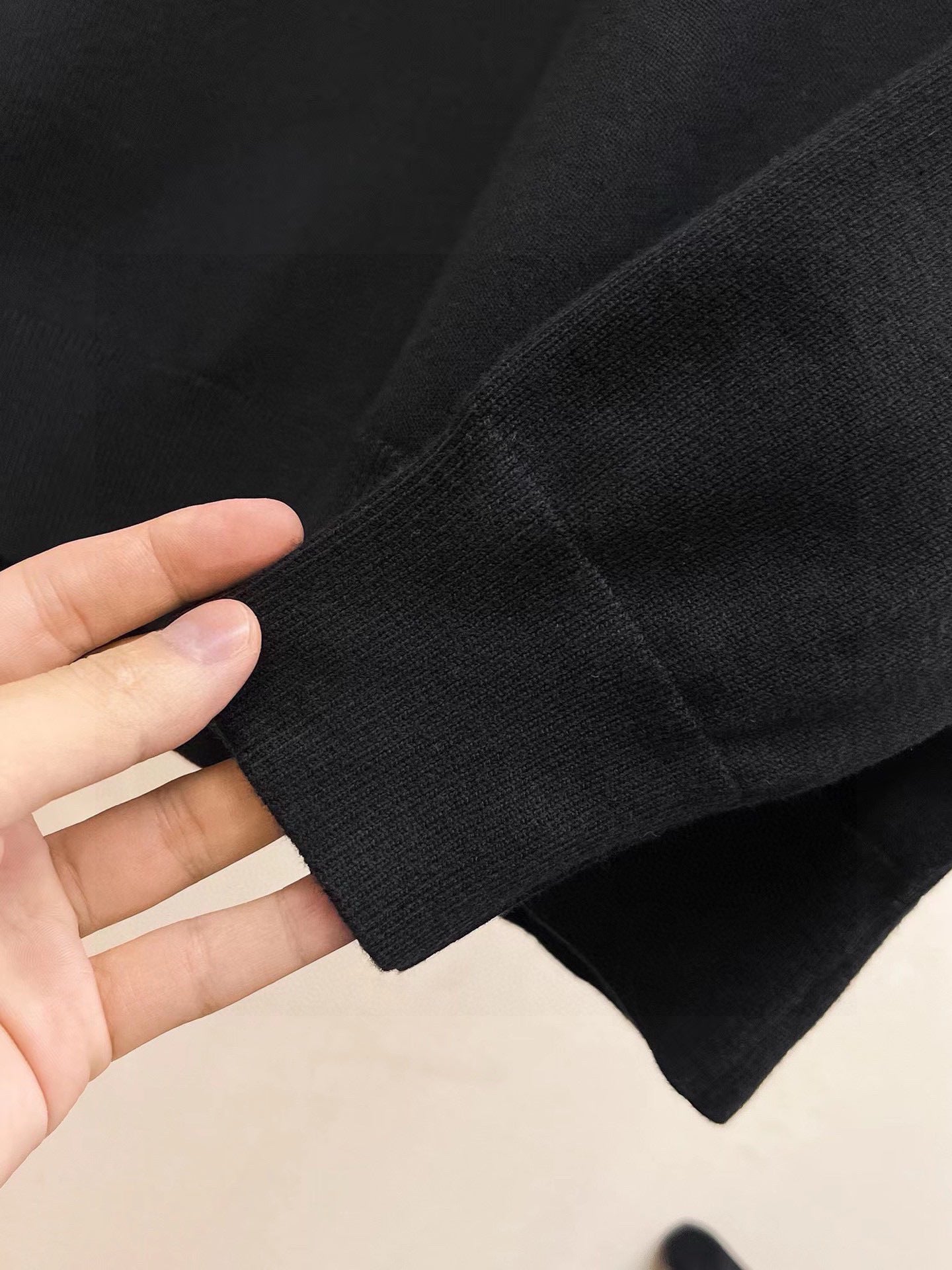 Black sweatshirt fabric close-up with sleeve knit texture