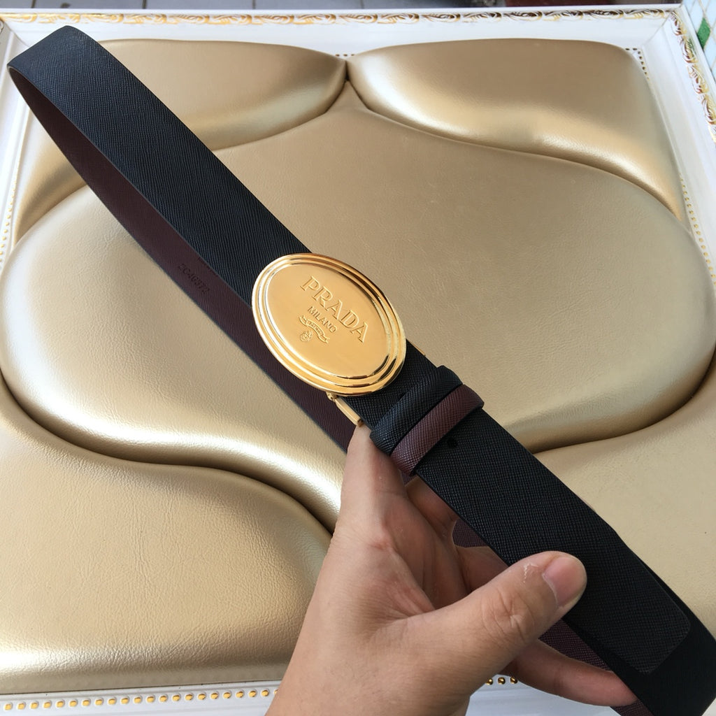 Prada belt with dark textured strap and gold oval buckle, clasp closed.