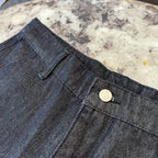 Dark denim shorts waistband detail with button and stitched fly seam