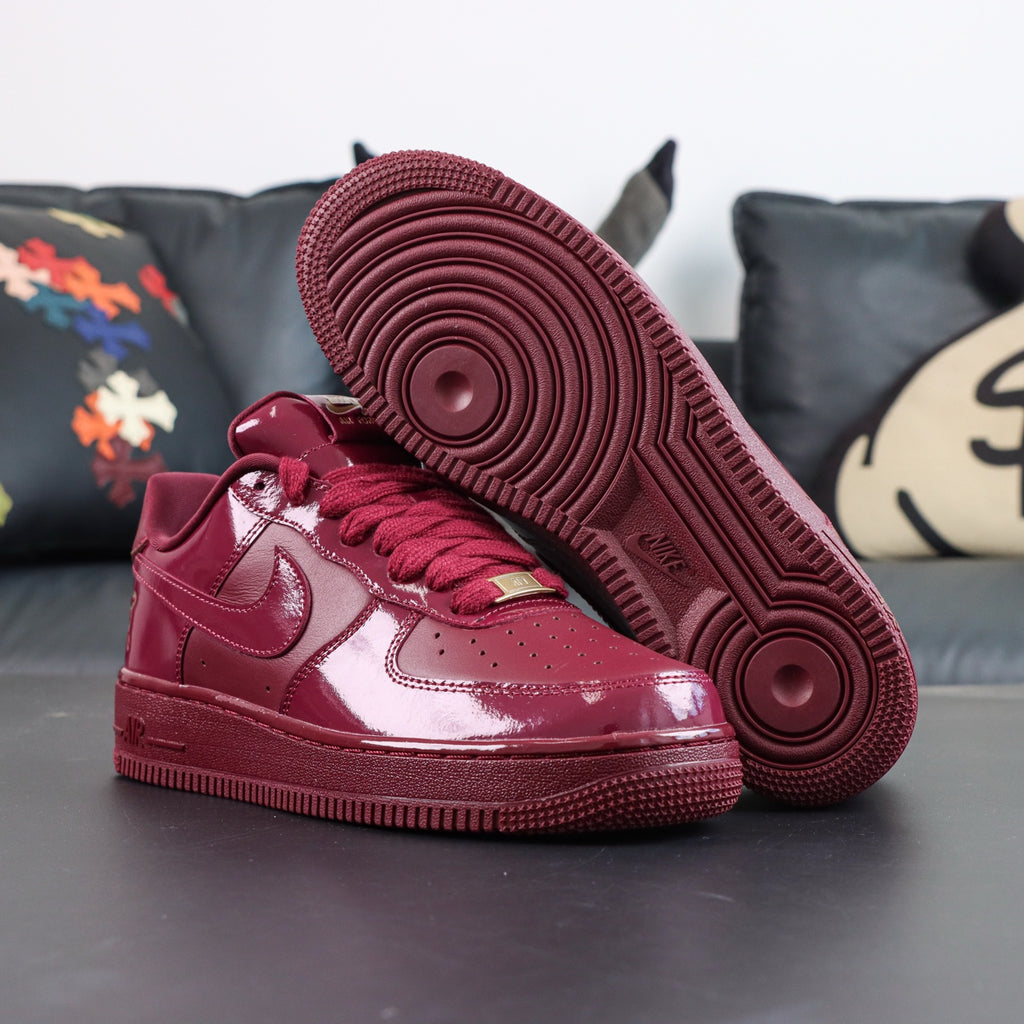 Burgundy low-top sneakers with Nike swoosh, lace-up front and chunky Air sole