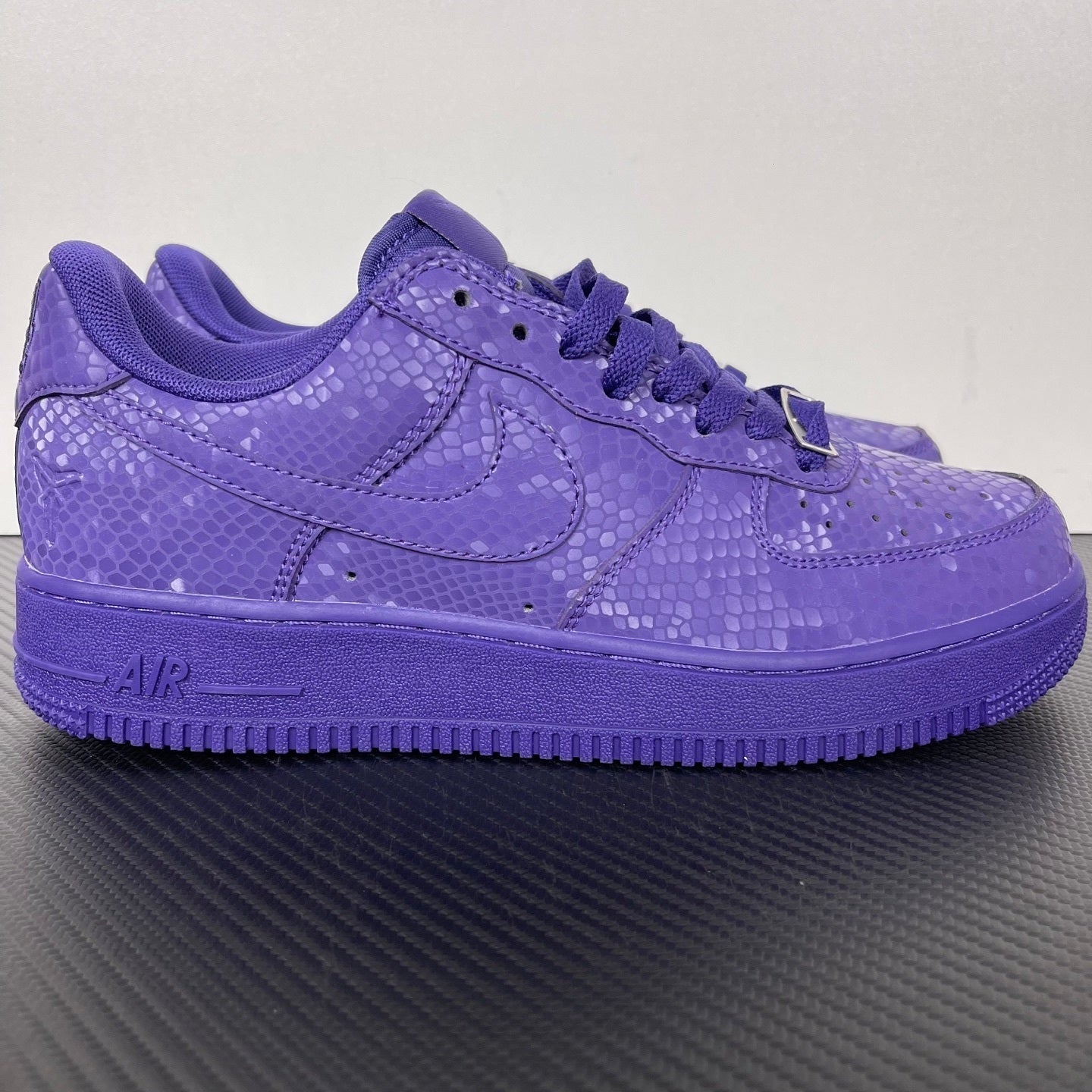 Purple low-top sneakers with lace-up closure and embossed textured upper