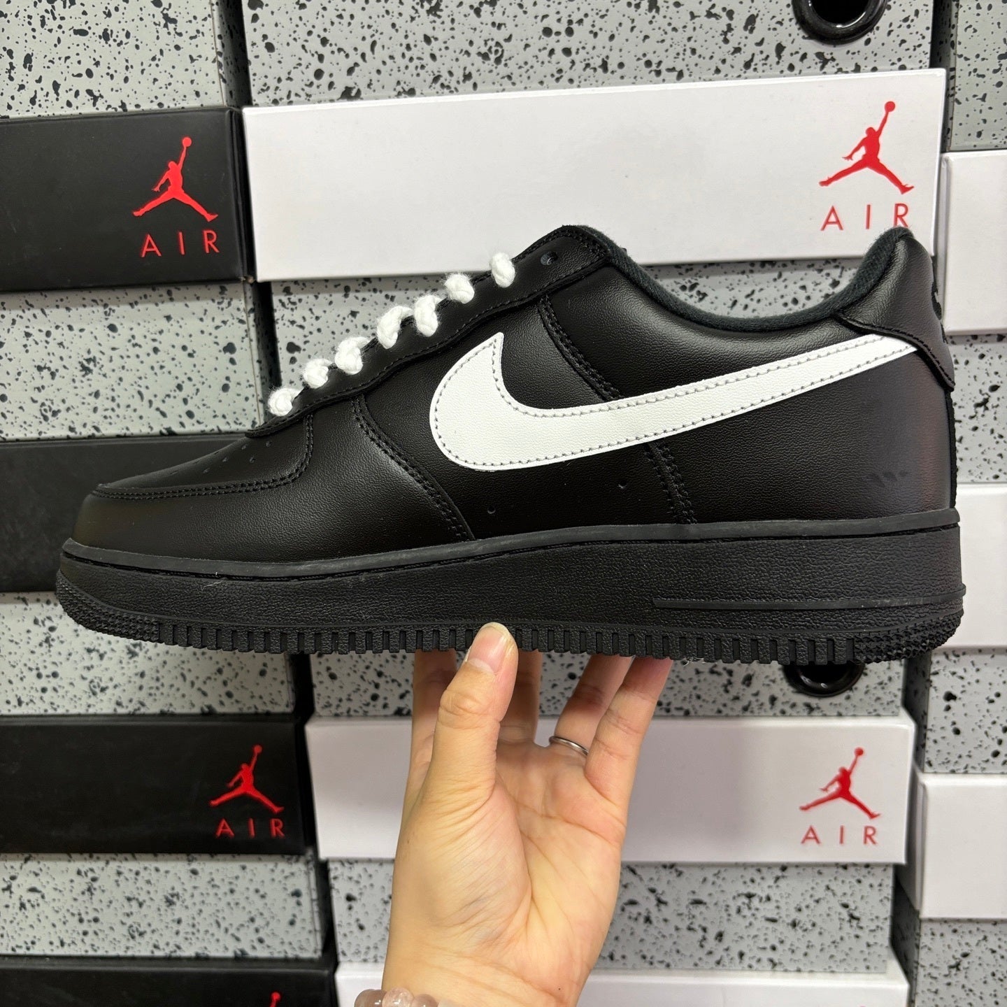 Black leather low-top sneaker with white swoosh and lace-up front
